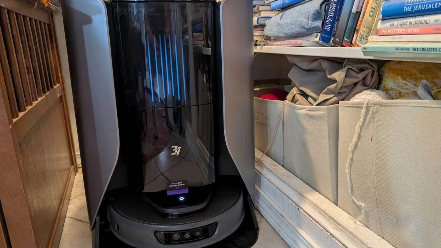 The robot vacuum cleaner is cleaning the corner of the closet.